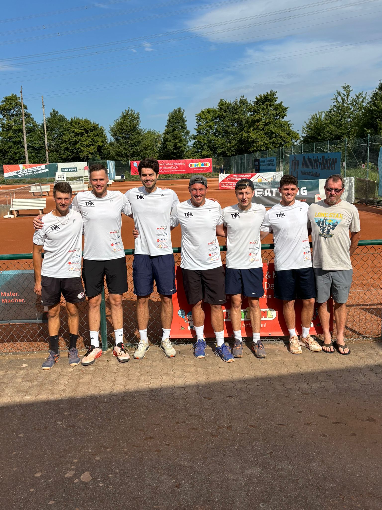 DJK Tennis Herren Mannschaftsbild vor dem Tennisplatz. 6 Mannschaftsspieler + Trainer